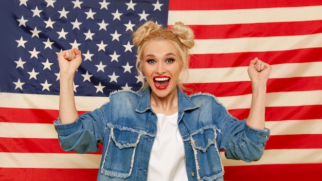 Fille américaine. Portrait de heureux de jeune femme surprise sur fond de drapeau USA.