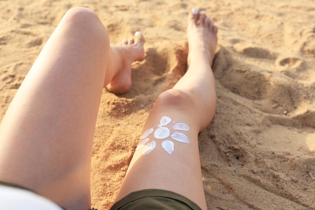 Fille appliquant un écran solaire sur ses jambes Soins de la peau Corps Protection solaire