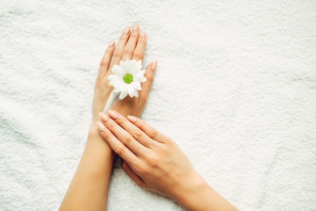 Photo fille applique la crème naturelle sur le gros plan de la main. vue de dessus des mains féminines