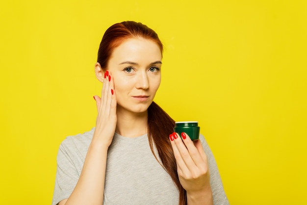 Une fille applique de la crème sur son visage