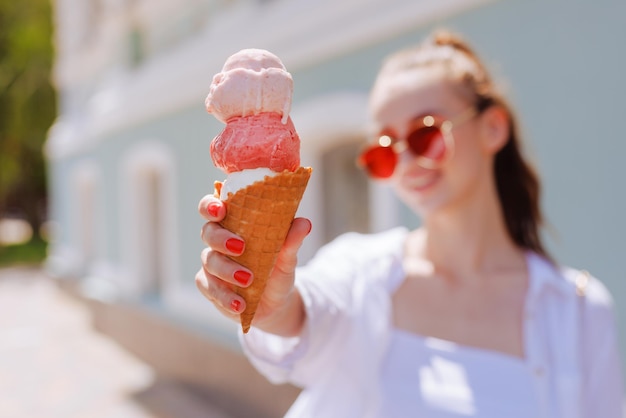 Fille appréciant la crème glacée dans un cône avec des boules de crème glacée