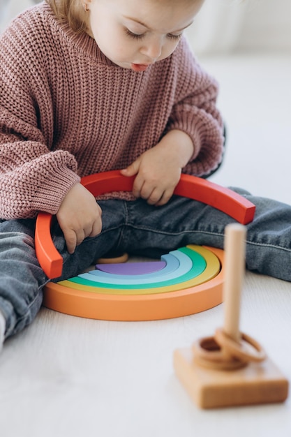 La Fille Apprend Les Couleurs En Jouant Avec Des Figurines Humaines Colorées De Jouets Cylindriques En Bois Et En Les Plaçant Dans Des Tasses De La Couleur Appropriée L'enfant Est Heureux D'avoir Terminé La Tâche Correctement