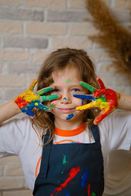 Fille artiste tachée de peinture en cours de dessin