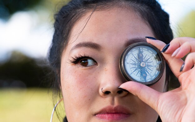 Photo fille asiatique avec une boussole dans les yeux