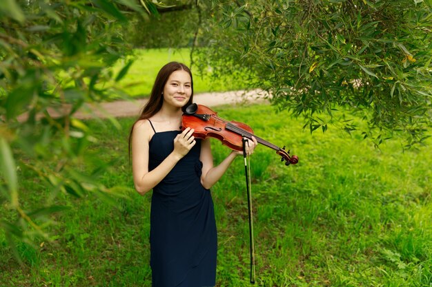 Fille asiatique dans la nature avec violon. photo de haute qualité