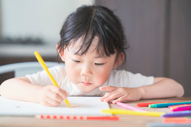 Fille asiatique dessin avec des stylos colorés