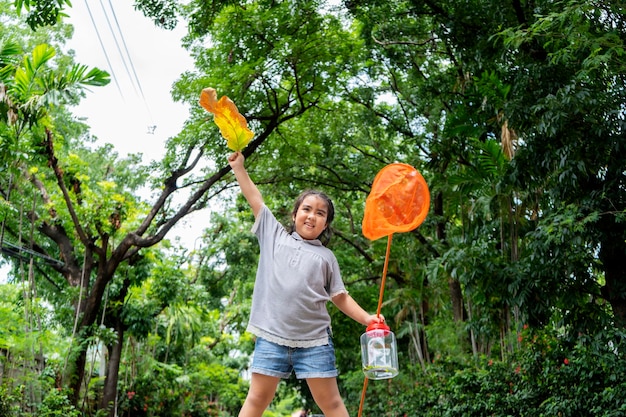 Une fille asiatique, elle s'aventure dans un vaste monde Avec un attrape-insectes Debout sur une colline et prête à attraper des insectes