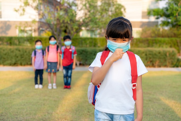 Fille asiatique enfant d'âge préscolaire étudiant portant un masque facial sain