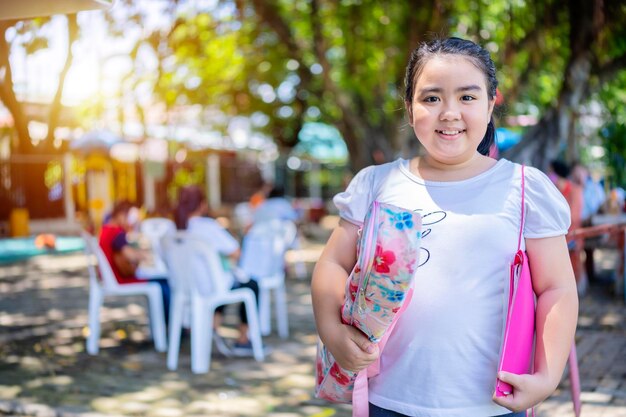 Une fille asiatique étudie la musique dans un jardin de l'école Concept de retour à l'école