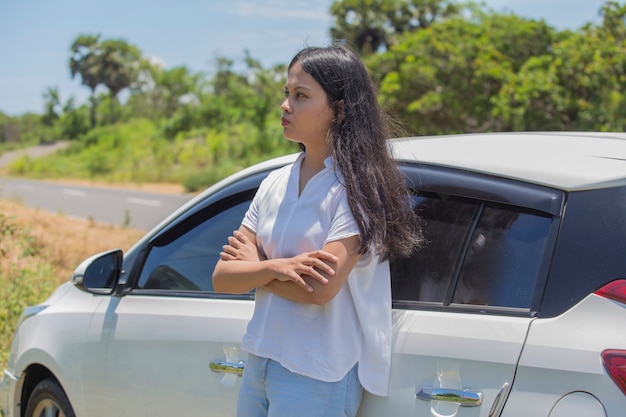 Fille asiatique folle debout à la voiture dans la rue