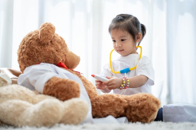 Une fille asiatique heureuse jouant à l'ours en peluche