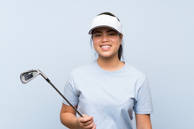 Fille asiatique jeune golfeur sur fond bleu isolé