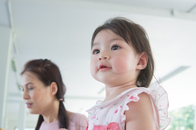 Fille asiatique jouant dans le parc avec le soutien de la mère.