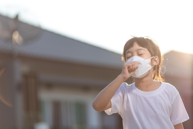 Fille asiatique portant un masque malade avec des éternuements sur le nez et une toux froide