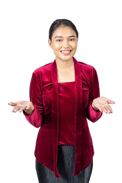 Fille asiatique portant des vêtements traditionnels de kebaya rouge avec la main de la paume ouverte montrant quelque chose