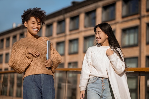 Fille asiatique regardant parler petite amie mulâtre