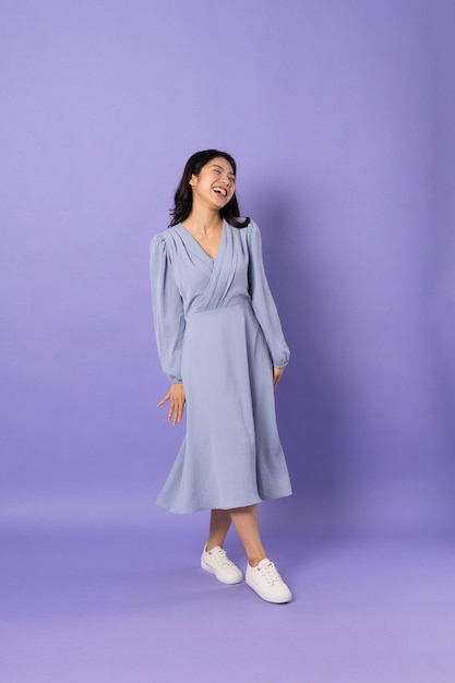 Fille asiatique en robe bleue sur fond violet