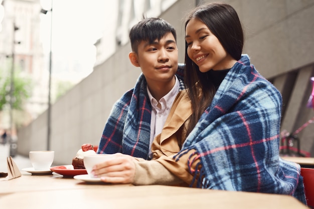 Fille asiatique souriante et garçon date romantique au café.