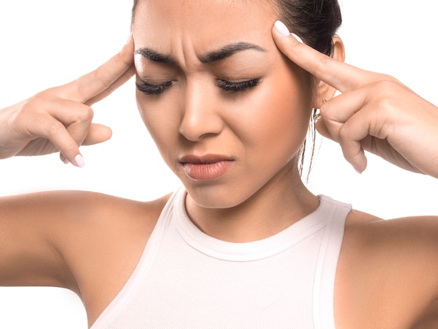 Fille asiatique tenant les mains sur les temples. Concept de maux de tête. Migraine.