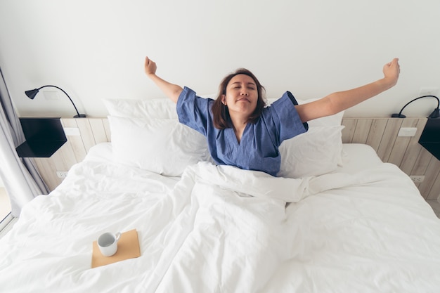 Fille asiatique Étirement du corps après le réveil du matin. Le rendre plus lumineux