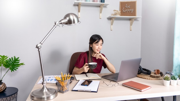 Fille asiatique travaillant à distance de la maison