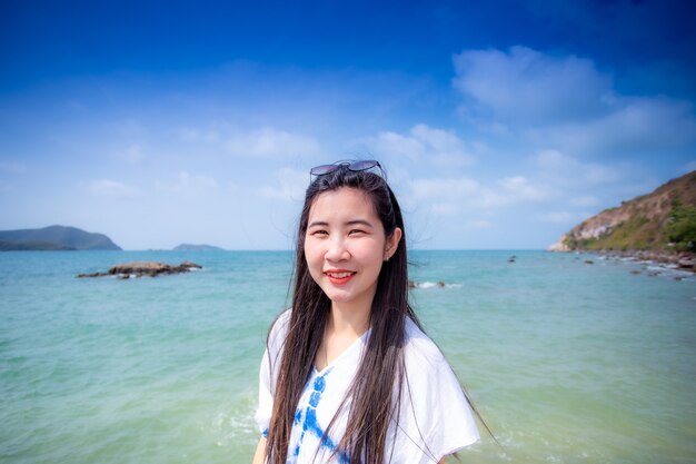 Fille asiatique avec vue sur la merPortrait d'une fille asiatique heureuse à la plage Belles vacances en été