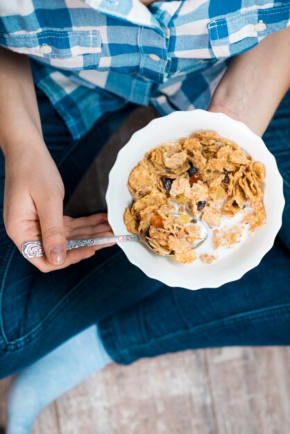 Photo fille avec une assiette de céréales à grains entiers avec du lait