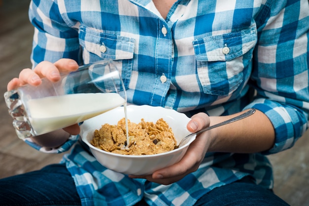 Fille avec une assiette de céréales à grains entiers et de lait