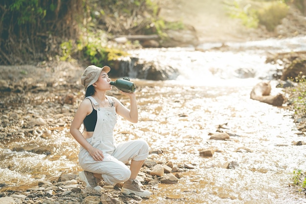 Fille assise au bord de l'eau potable