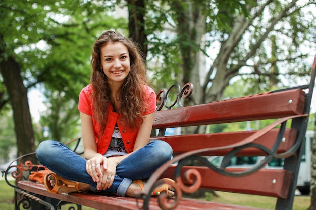 Fille assise sur un banc dans la rue.