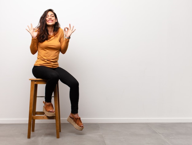 fille assise sur une chaise en méditant et se sentant excitée