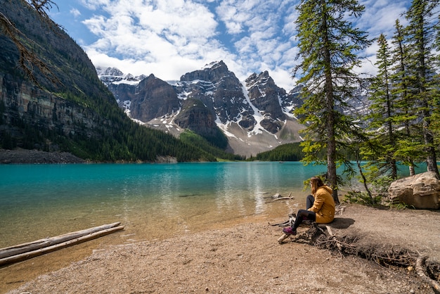 Photo une fille assise à côté du lac moraine