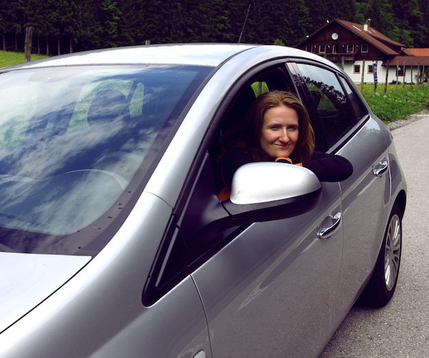 Fille assise dans la voiture et regardant la caméra