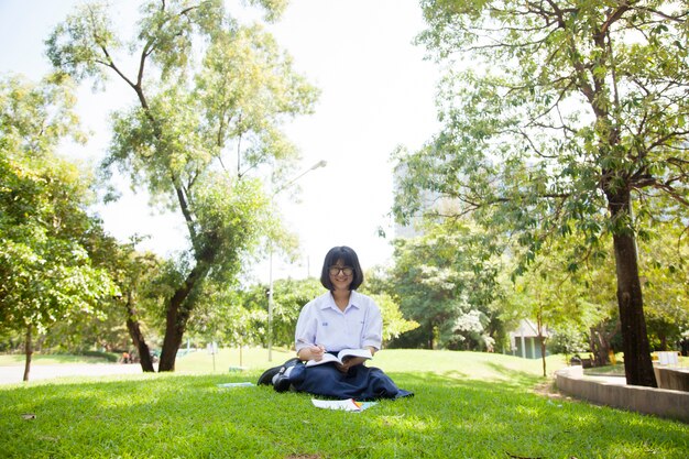 Fille assise devoirs et lecture.