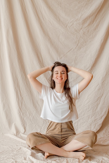 Fille assise sur fond de tissu