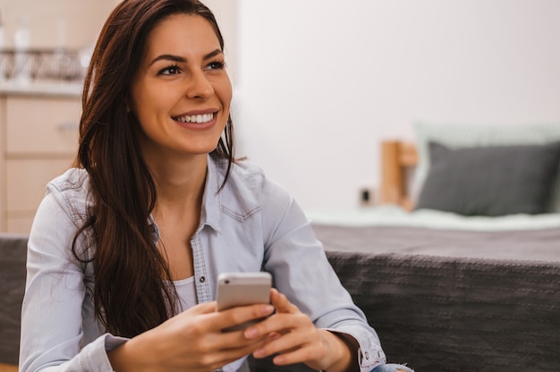 Fille assise à la maison et écrivant un message