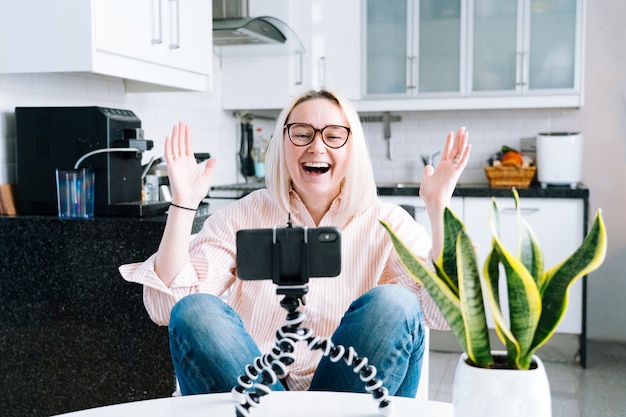 Fille assise à la maison et tenant un appel vidéo.