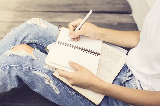 Fille assise sur le sol et a écrit dans un cahier