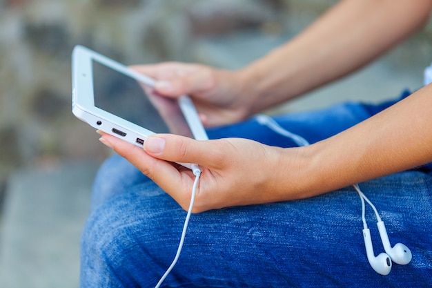 Fille assise avec une tablette dans les mains