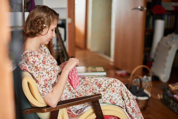 Fille assise tricotant un produit fabriqué à la main