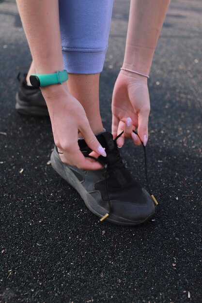 Fille attachant les lacets de ses chaussures de sport noires
