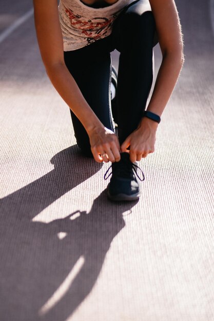 fille attachant des lacets sur un tapis roulant