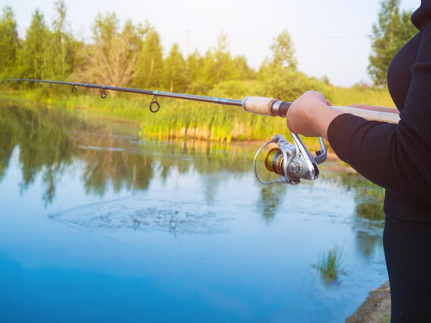 Une fille attrape du poisson en tournant sur le lac