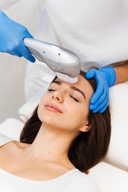 Une fille attrayante se fait faire un lifting à la clinique de cosmétique Ultraformer procédé de lifting non chirurgical