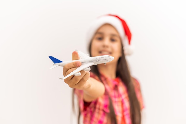 Fille au bonnet de noel tenant un avion modèle