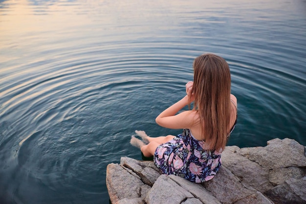 Photo fille au coucher du soleil sur le fond du lac