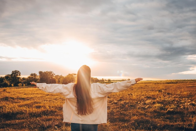 Fille au coucher du soleil profitant de la nature