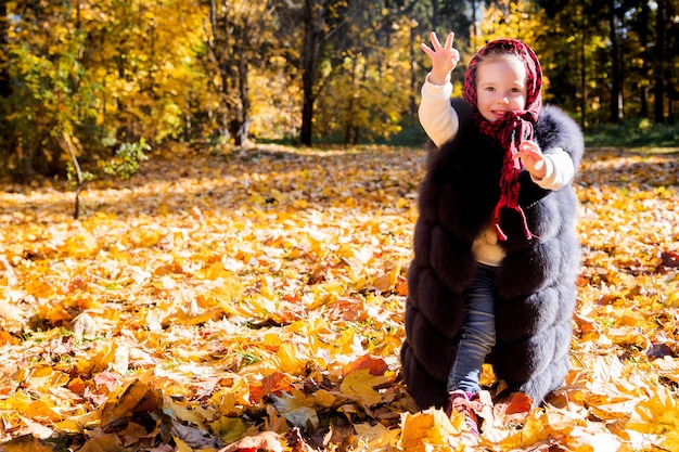 Fille au gilet de maman en automne parc