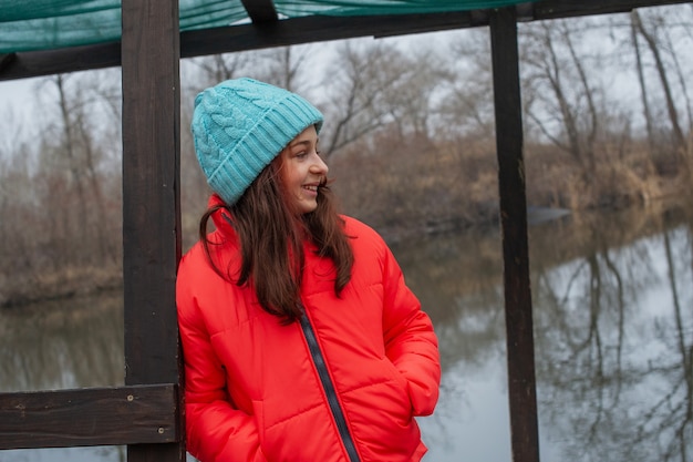 Fille au lac ou à la rivière. Fille en vêtements d'hiver