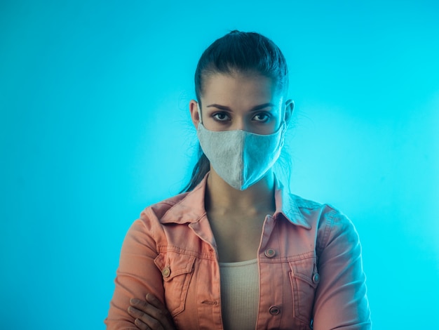 Fille au masque gris sur le mur bleu sarcelle